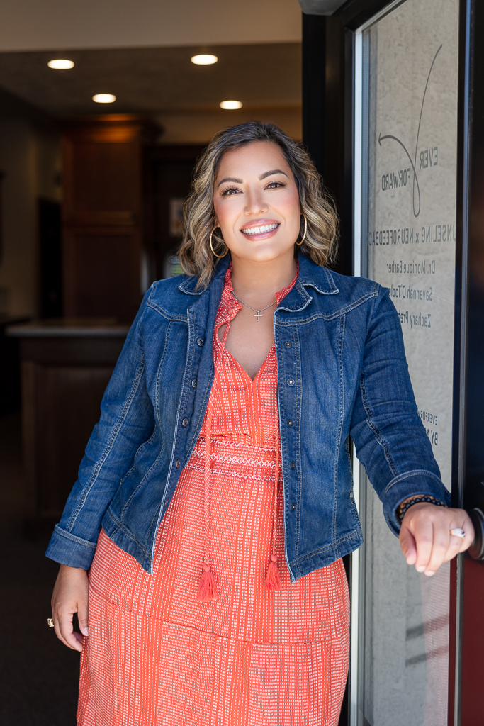 Photo of Dr. Monique Barber opening the door for guests at Ever Forward Counseling